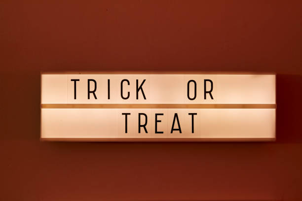 istock Trick or treat text displayed on a LED lightbox red ambient light in the room 1281791316