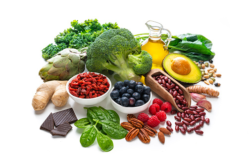 Healthy eating: group of antioxidant food shot on white background. The composition includes healthy fruits, vegetables, nuts and seeds like blueberries, raspberries, goji berries, dark chocolate, artichoke, Kidney beans, ginger, garlic cloves, avocado and olive oil. High resolution 42Mp studio digital capture taken with SONY A7rII and Zeiss Batis 40mm F2.0 CF lens