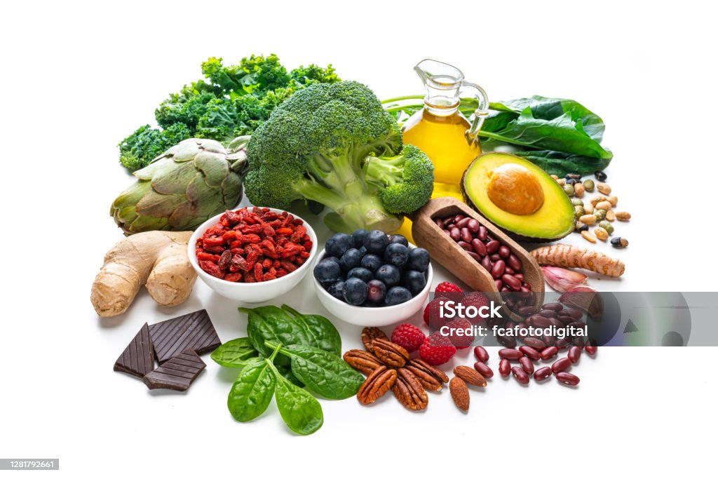 Group of vegan food rich in antioxidants on white background Healthy eating: group of antioxidant food shot on white background. The composition includes healthy fruits, vegetables, nuts and seeds like blueberries, raspberries, goji berries, dark chocolate, artichoke, Kidney beans, ginger, garlic cloves, avocado and olive oil. High resolution 42Mp studio digital capture taken with SONY A7rII and Zeiss Batis 40mm F2.0 CF lens White Background Stock Photo