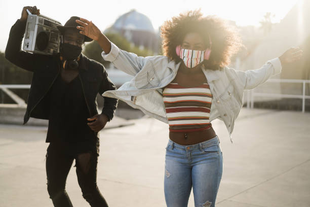 afrikanische menschen tanzen im freien hören musik - fokus auf mädchen gesicht - hip hop hipster afro men stock-fotos und bilder