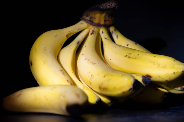 istock Bunch of bananas on a dark background. 1281797061
