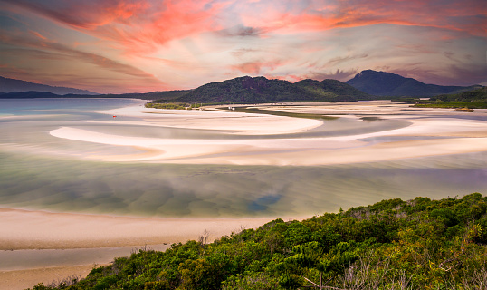 Beautiful sunrise from hill inlet lookout on Whitehaven beach at Whitsunday Island near Airlie Beach, Australia at low tide. The beautiful green color is very rare.