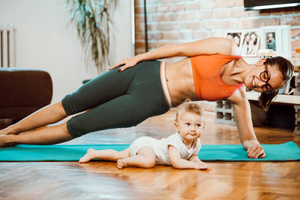 istock Woman exercising at home with baby 1281801043
