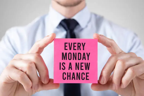 Businessman is holding a business card with Every Monday is a new chance message