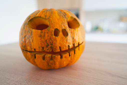 Photograph of a carved out pumpkin on a table for Halloween decoration.
