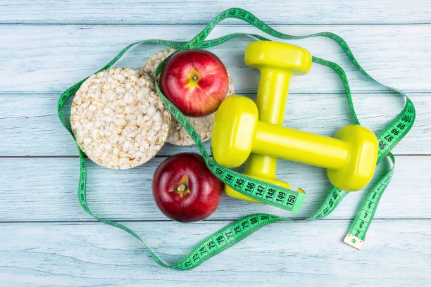 istock bread Apple and dumbbells on a blue wooden background 1281808899