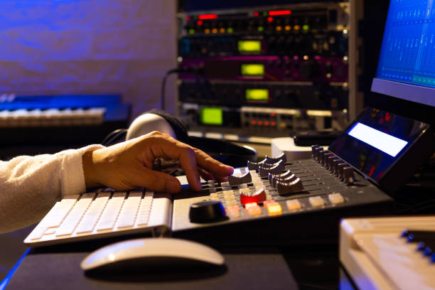 istock Sound engineer hands adjusting volume on digital audio control surface for mixing audio tracks on computer. Post production, broadcasting, recording concept 1281810470