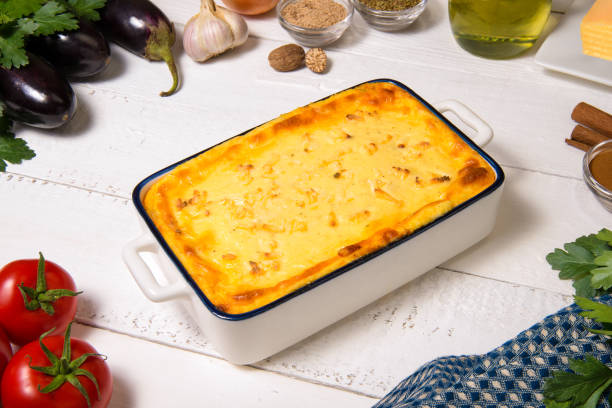 Greek Moussaka in casserole dish with the ingredients. stock photo