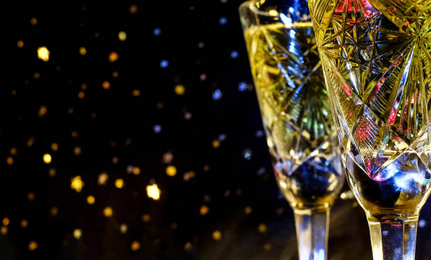 istock Two champagne glasses on dark bokeh background. Selective focus, with copy space 1281815818