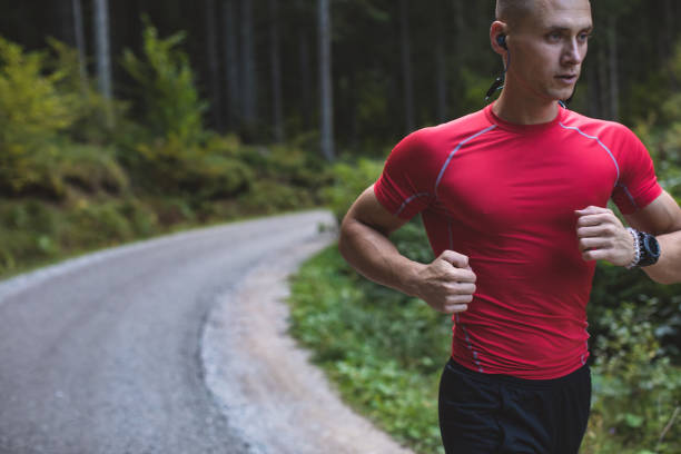 istock Young man runs in pine forest at sunrise 1281816673