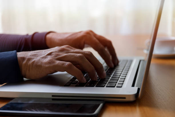 istock Close up businessman using laptop computer at home. Close up male hands typing on laptop keyboard in office. Man hands using laptop keyboard. Close-ups of technology in use concept. 1281817089