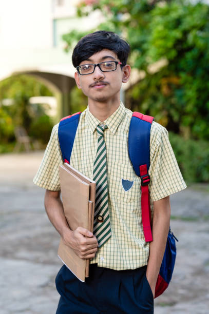istock Cheerful high school student in uniform holding books 1281821682
