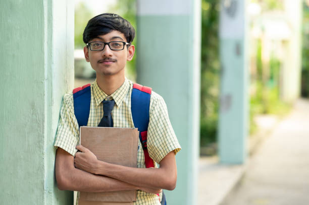 istock Cheerful high school student in uniform holding books 1281821788