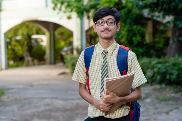 istock Cheerful high school student in uniform holding books 1281821809