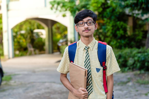 istock Cheerful high school student in uniform holding books 1281822036