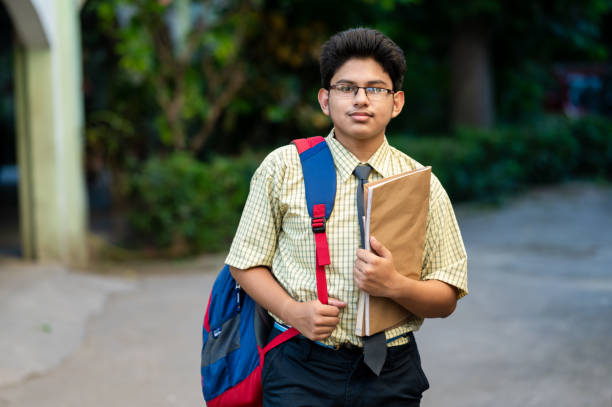 istock Cheerful high school student in uniform holding books 1281822084
