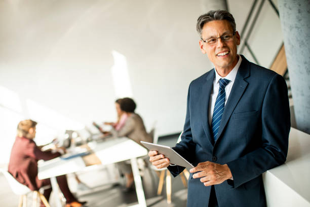 istock Handsome businessman using his tablet in the office 1281823614