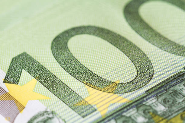 One hundred Euro (100) banknote details in a macro shot. Selective focus