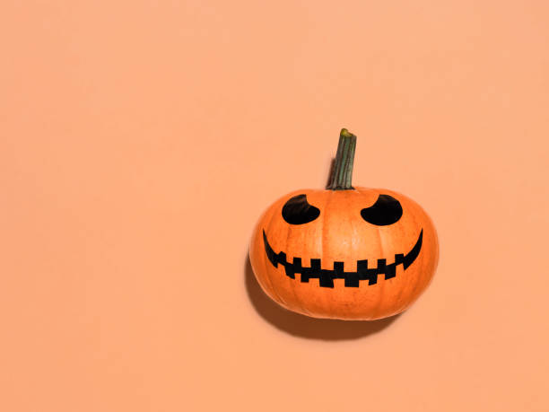 istock Halloween pumpkin in hand on orange background. 1281824722