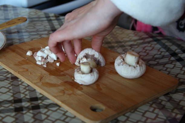 istock Woman cuts mushrooms on a cutting board 1281826988