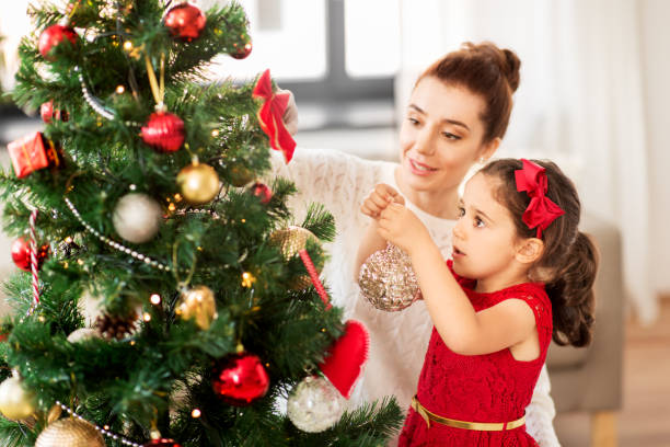 istock happy family decorating christmas tree at home 1281827010