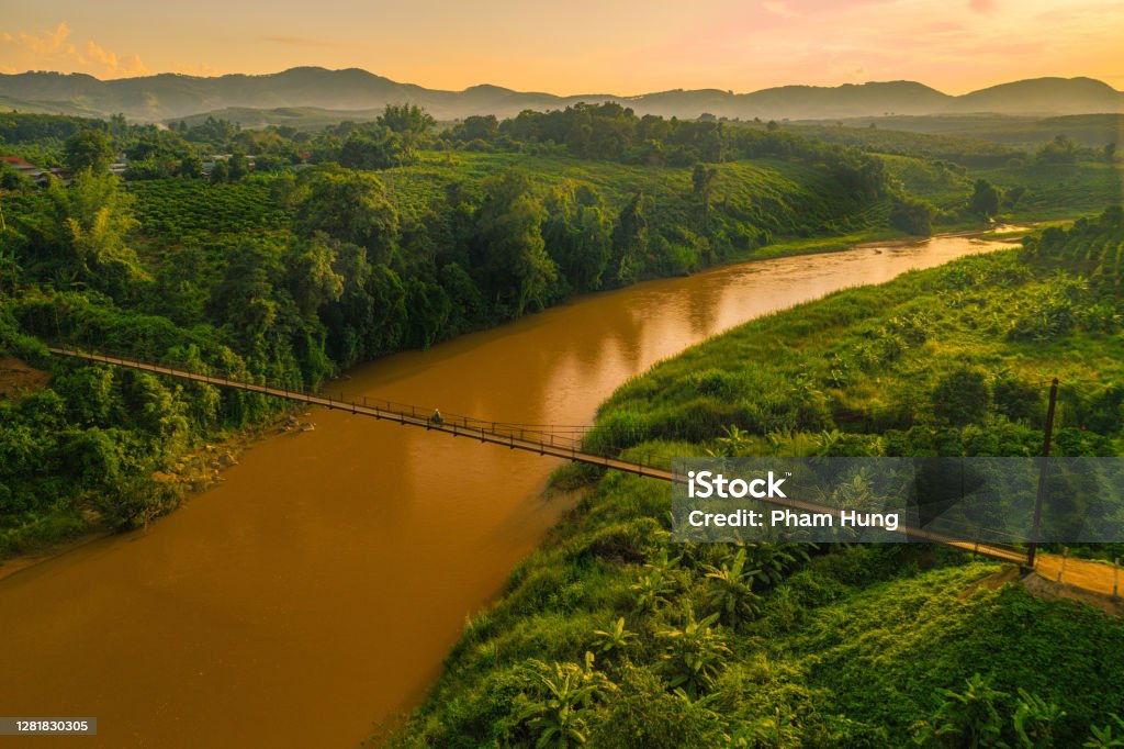 Suspension bridge in Kon Tum province Drone view of of cable-stayed suspension bridge in sun set, Kon Tum province River Stock Photo