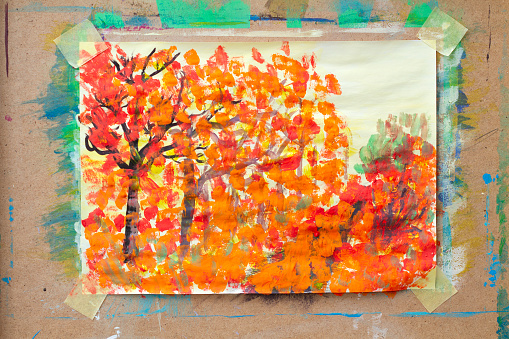 Painting by a young artist depicting autumn trees, attached to an easel
