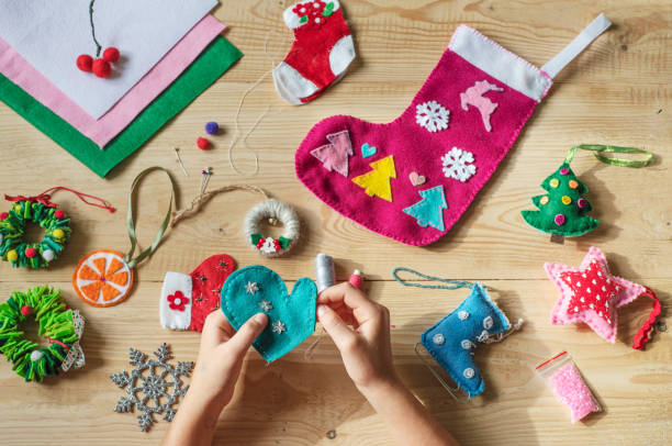 istock Christmas crafting, hands holding needle and sewing felt heart 1281837012
