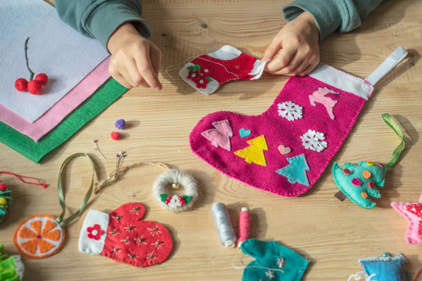Christmas crafting, hands holding needle and sewing felt heart