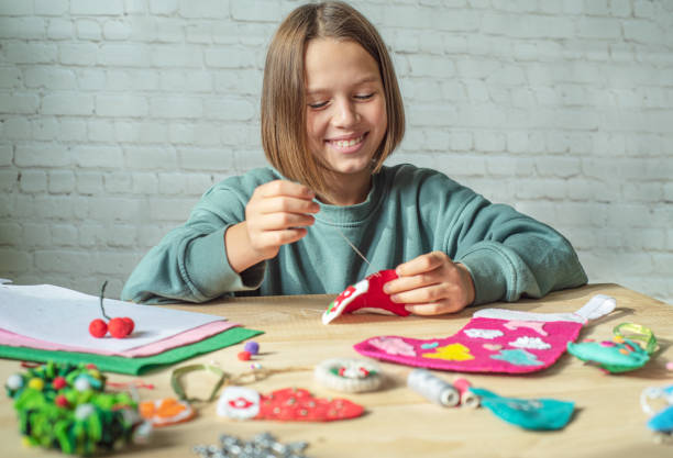 istock Smiling girl making Christmas felt stocking, Christmas crafting 1281837652
