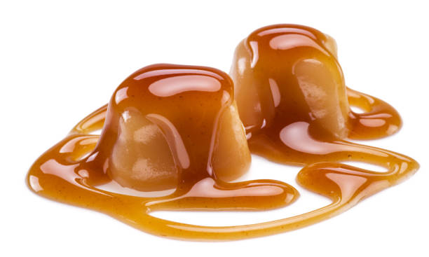 istock Caramel candies covered with melted sugar caramel isolated on white background. 1281839961