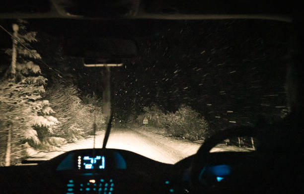 nachtfahrt im schneesturm - drivers point of view country road snowing blizzard stock-fotos und bilder