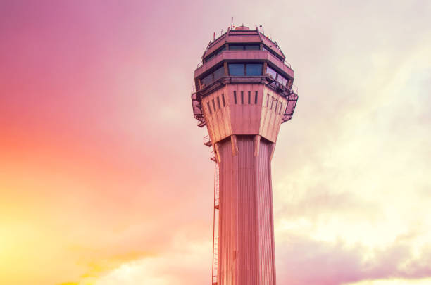 Airport traffic control tower lonely with background of the sunset orange pink light sky and clouds. Airport traffic control tower lonely with background of the sunset orange pink light sky and clouds terminal tower stock pictures, royalty-free photos & images