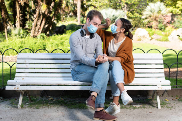 istock Couple sitting on a bench during pandemic 1281842551