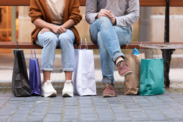 istock Couple sitting on a bench with shopping bags 1281842609