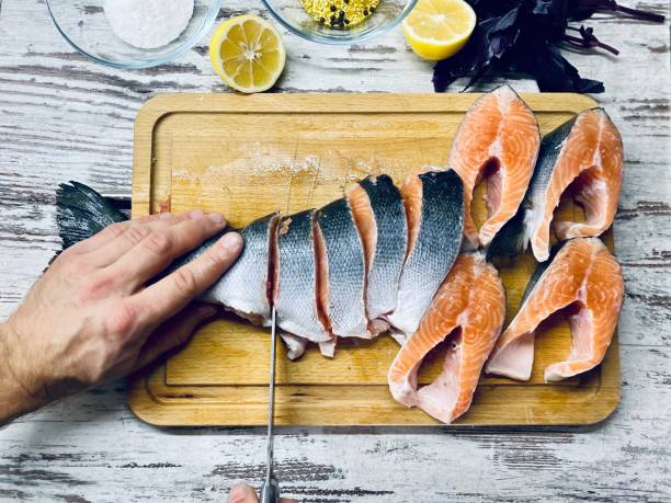 istock A fair-skinned man cuts raw fish for cooking. 1281846896