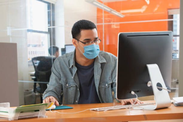 istock Man working at the office wearing a protective mask 1281853042