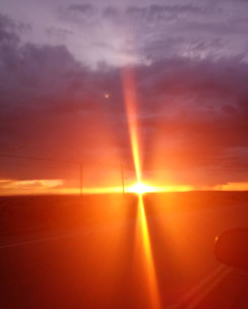 The sun is setting and the rays of the sun form a cross