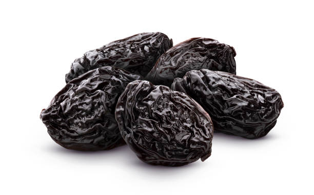 Prunes isolated on white background with clipping path Prunes isolated on white background, heap of dried plums plum stock pictures, royalty-free photos & images