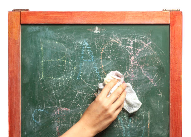 istock Hand holding cloth erase on green chalkboard 1281856514