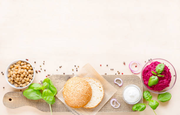 Top view ingredients for cooking vegan burgers on light wooden background with copy space flat lay