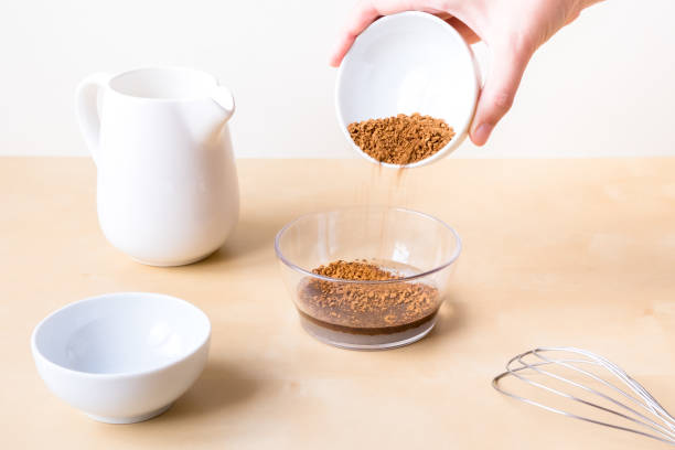 istock How to make dalgon coffee. Step by step photo instruction. Step 3. Add coffee and sugar to the water. Ingredients - instant coffee, sugar, water, milk and a whisk for whipping on a wooden background 1281857625
