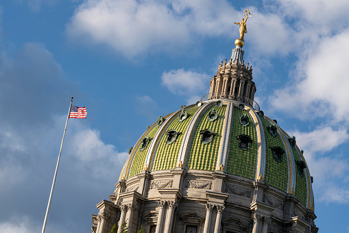 The Pennsylvania State Capitol Dome with American Flag set near sunset