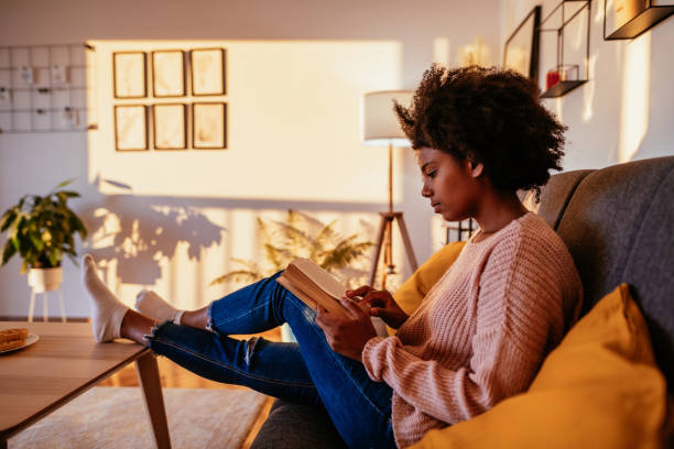 istock Mixed race student reading book at home on sunny day 1281862299