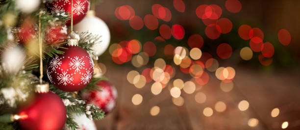 adornos de árbol de navidad, rojos y blancos contra un fondo de luces desenfocadas - merry christmas fotografías e imágenes de stock