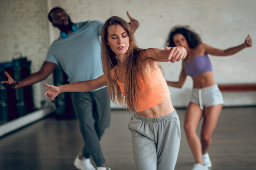 Mujer aprendiendo coreografía de hip-hop con sus compañeros de grupo photo