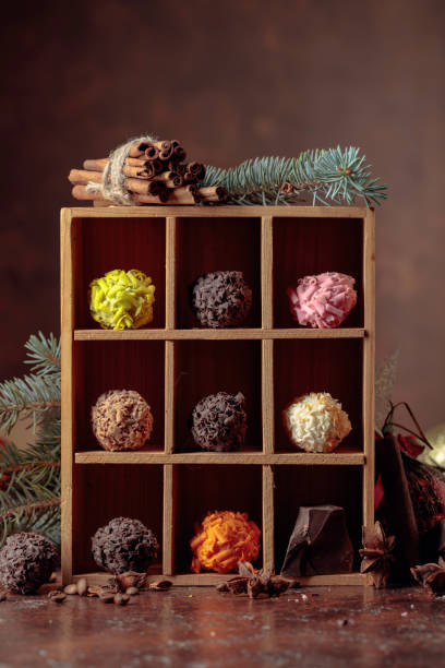 istock Chocolate candy in wooden box and Christmas decorations on a old brown table. 1281863690