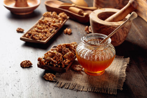 miel et noix sur une vieille table en bois. - breakfast stick honey meal photos et images de collection