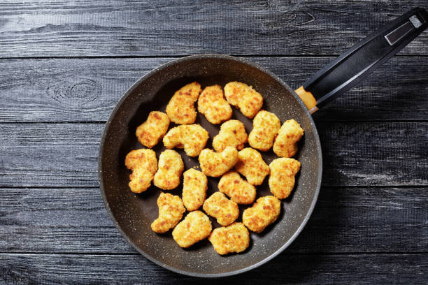 istock Chicken nuggets fried on a skillet, served on a wooden background 1281867559