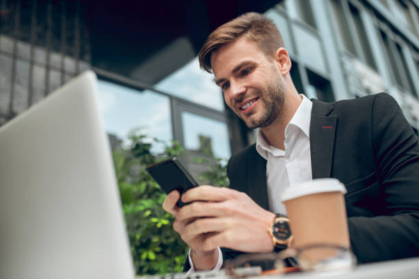 istock Handsome young businessman having coffee and texting 1281870035